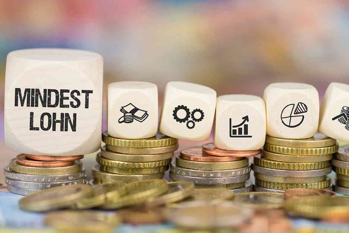 © magele-picture - stock.adobe.com Münzen und Würfel mit Symbolen und Beschriftung Mindestlohn