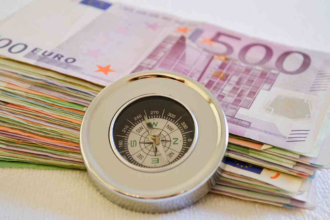 © Martina Wendt - stock.adobe.com Geldscheine mit eine Kompass davor