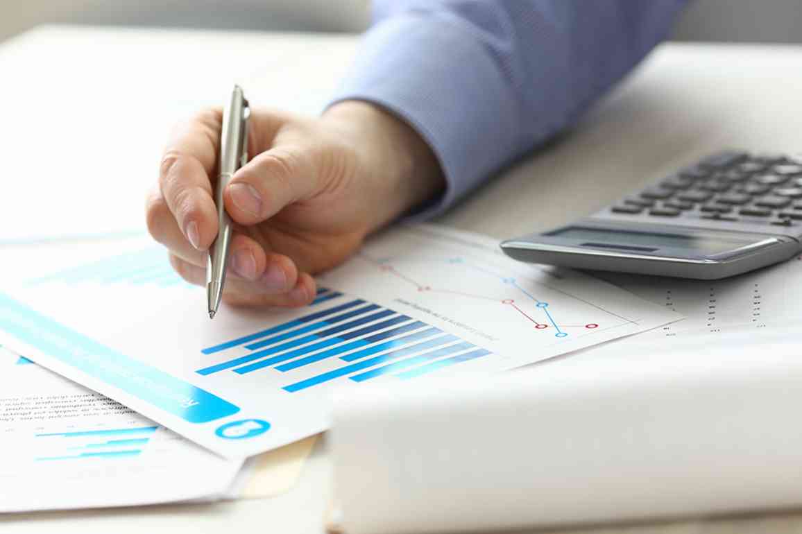 Person zeigt mit Stift auf Akten