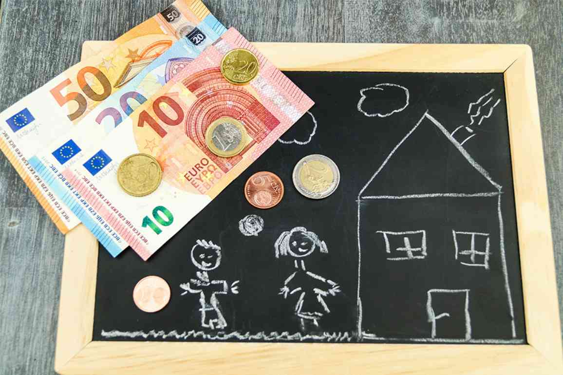 Tafel mit Kinderzeichnung darauf und Bargeld